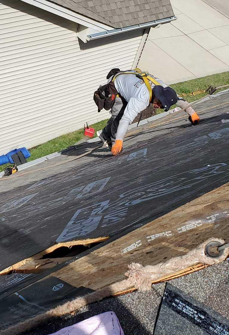 Worker repairing roof with safety harness and tools
