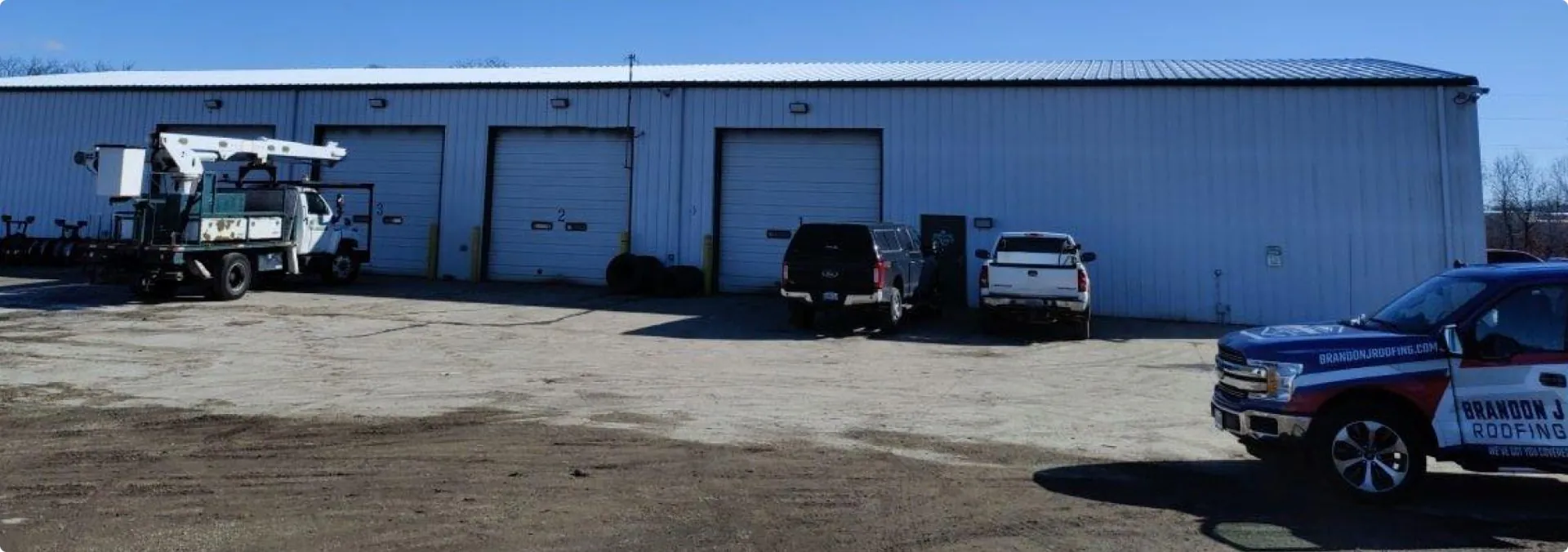 Commercial garage with trucks parked outside.