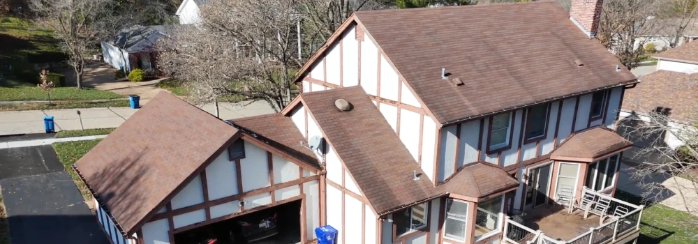 Aerial view of a suburban house with brown roof.